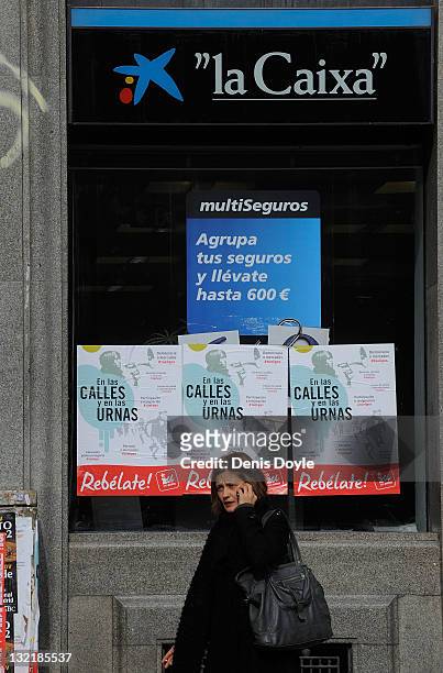 Election posters for the United Left political party are stuck to the window of a branch of La Caixa sevings bank on November 10, 2011 in Madrid,...