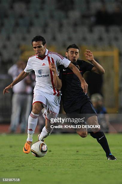 Egyptian footballer Hazem Emam of Zamalek club competes with Eduardo Salvio of Atletico Madrid during their friendly football match in Cairo on...