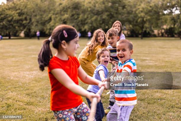 gruppe von kindern in einem tauziehen spiel im freien - ferienlager stock-fotos und bilder