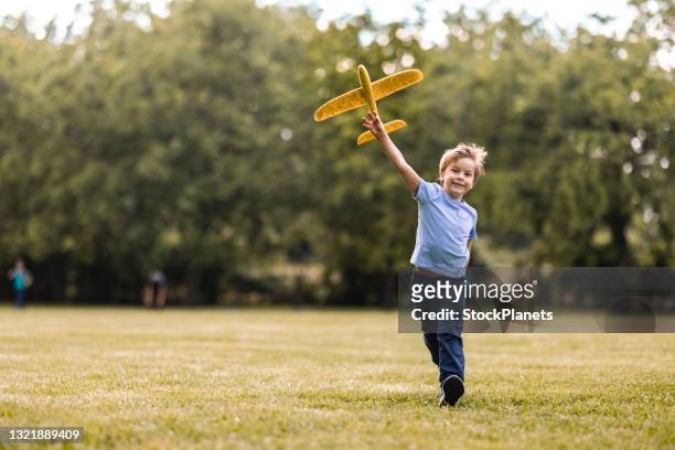 boy is playing with airplane toy in public park - one boy only stock pictures, royalty-free photos & images
