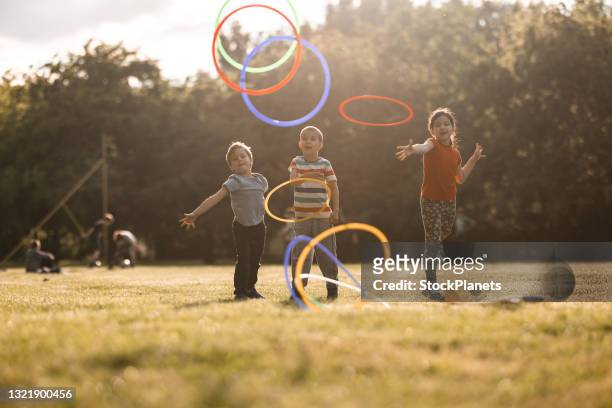 grupp av barn som leker whit hula hoops i den offentliga parken - ring toss bildbanksfoton och bilder
