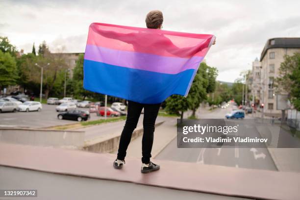 ein mann hält die lesbische flagge, um seine unterstützung zu zeigen - gay flag stock-fotos und bilder