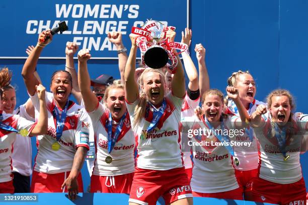 Jodie Cunningham of St Helens lifts the Betfred Women's Challenge Cup trophy as her team mates celebrate after during the Betfred Women's Super...