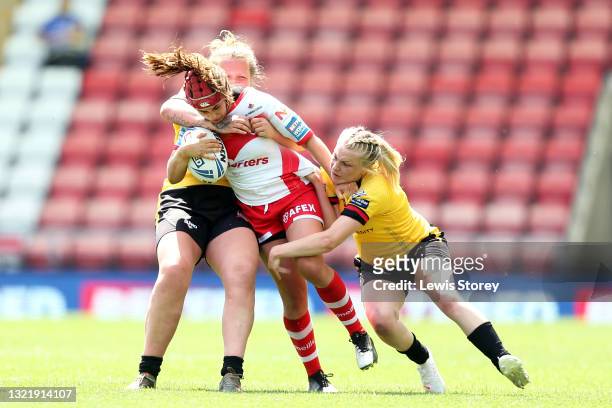 Emily Rudge of St Helens is tackled by Rhiannion Marshall and Ash Hyde of York City Knights during the Betfred Women's Super League Cup Final match...