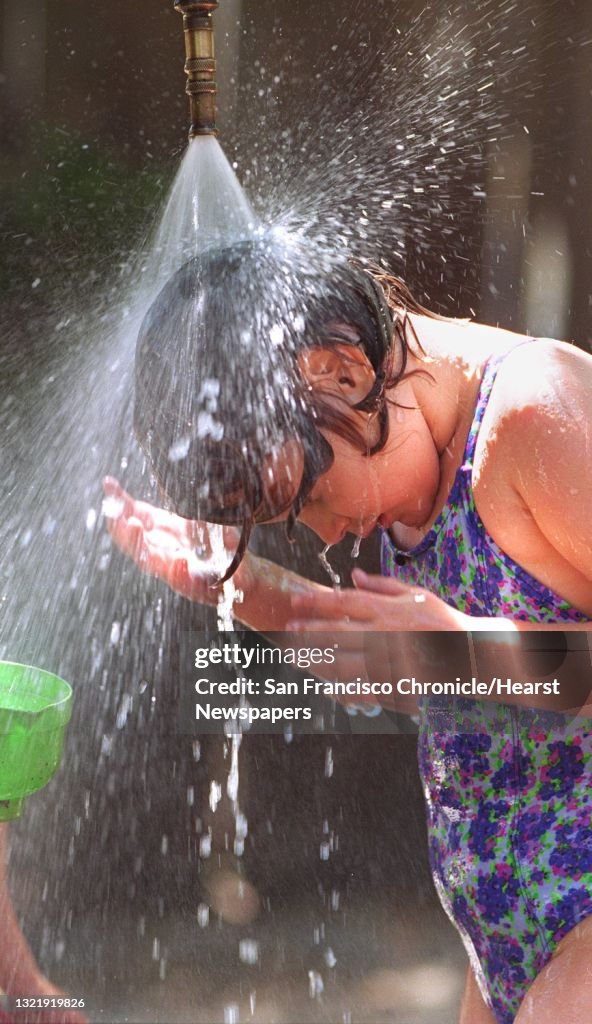 HOT/C/28APR96/MN/MACOR Hot temperatures in San Francisco calls for a "Spray Day" at Montessori School-The San Francisco School. Sophie Nunberg cools off under a stream of water. Chronicle Photo: MIchael Macor