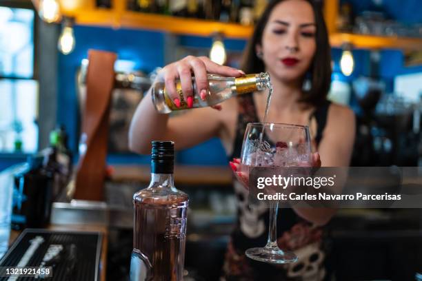 waitress pouring tonic into a crystal gin and tonic glass - hipster barkeeper stock pictures, royalty-free photos & images