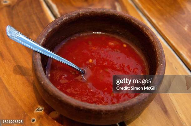 pottery bowl of red chili salsa on a wooden table - salsa sauce stock pictures, royalty-free photos & images