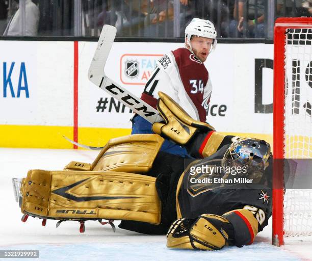 Carl Soderberg of the Colorado Avalanche looks back at Marc-Andre Fleury of the Vegas Golden Knights as he falls into a goal post while defending...