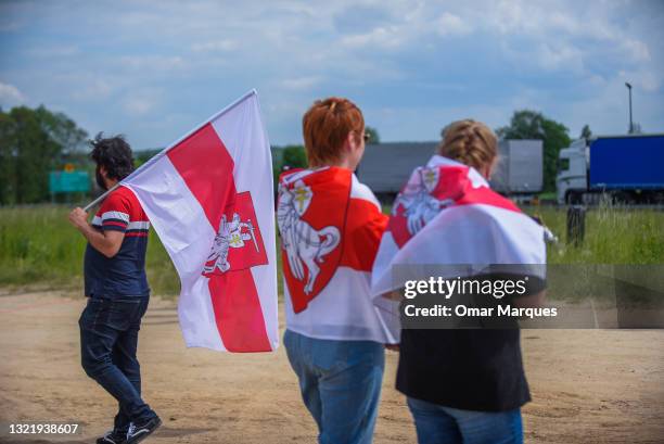 Belarusians hold historical Belarus opposition flags as they take part in a protest at the Polish-Belarusian border crossing on June 05, 2021 in...