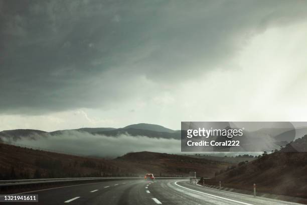 highway in stormy weather with dramatic sky - rain road stock pictures, royalty-free photos & images