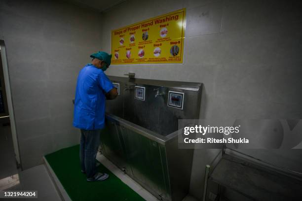 An ear, nose and throat specialist doctor washes his hands after performing surgery to remove mucormycosis from a patient who recovered from Covid-19...