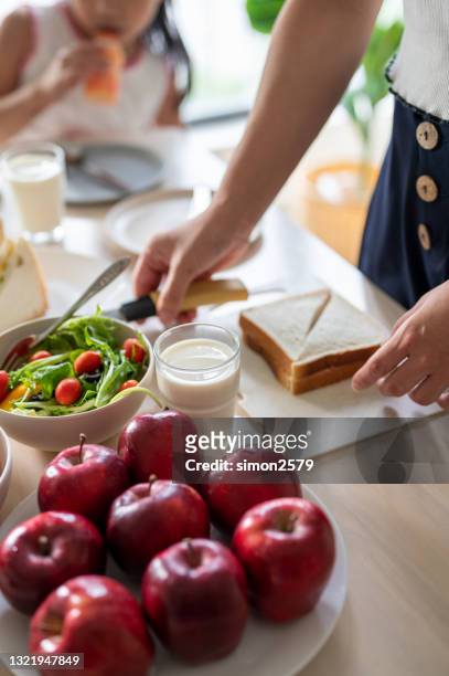 young woman making a sandwich for her family - making sandwich stock pictures, royalty-free photos & images