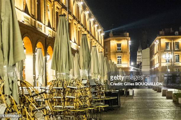Chaises empilées sur une terrasse de café fermée sur la Place du Capitole le soir à Toulouse le 5 novembre 2020.