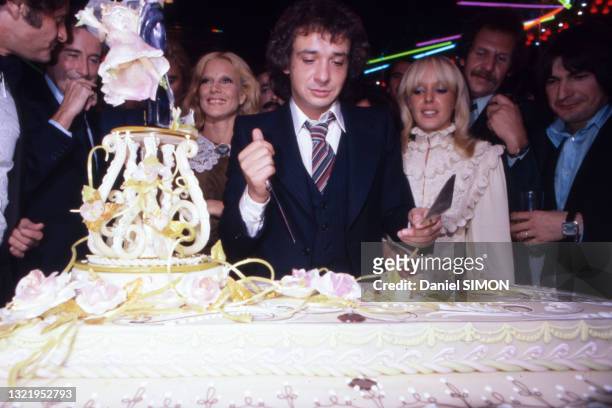 Michel Sardou et Babeth coupe leur gateau de mariage en présence de Sylvie Vartan lors de la soirée à l'Elysée Matignon à Paris le 14 octobre 1977