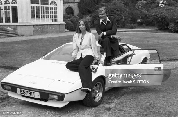 Barbara Bach et Roger Moore posent à coté d'une 'Lotus Esprit' le 8 septembre 1976 à Londres