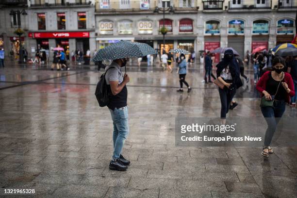 Citizens take shelter from the rain during a demonstration against the rise of light in the Puerta del Sol, on 5 June, 2021 in Madrid, Spain. It is...