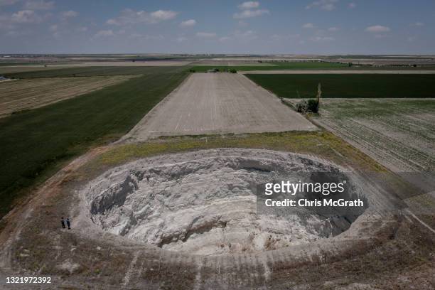 In an aerial view, Geology Professor Fetullah Arik and Geologist Arif Delikana inspect a large sinkhole in a field on June 03 in Karapinar, Turkey....