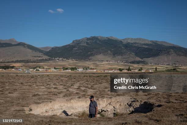 Geologist Arif Delikana takes measurements and inspects a sinkhole on June 03 in Karapinar, Turkey. In Turkey’s Konya province, the heart of the...