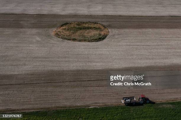 In an aerial view, a tractor passes a large sinkhole in a field on June 03 in Karapinar, Turkey. In Turkey’s Konya province, the heart of the...