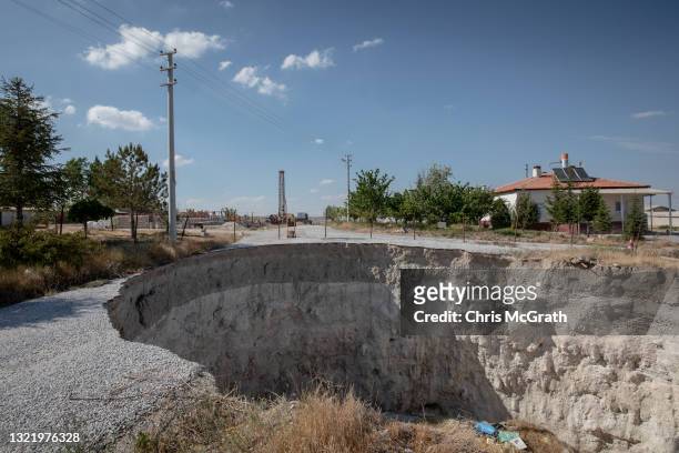 Large sinkhole is seen cutting a road in the village of Ekmekci on June 03 in Karapinar, Turkey. In Turkey’s Konya province, the heart of the...