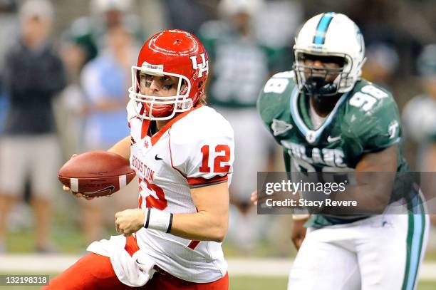 Cotton Turner of the University of Houston Cougars is pursued by Cedric Wilson of the Tulane Green Wave during a game being held at the Mercedes-Benz...