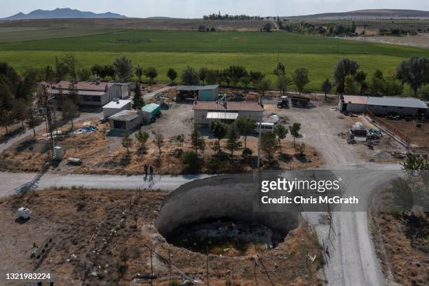In an aerial view, a large sinkhole is seen cutting a road in the village of Ekmekci on June 03 in Karapinar, Turkey. In Turkey’s Konya province, the...