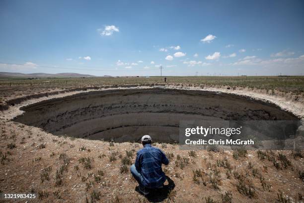 Geology Professor Fetullah Arik takes measurements next to a large sinkhole on June 03 in Karapinar, Turkey. In Turkey’s Konya province, the heart of...