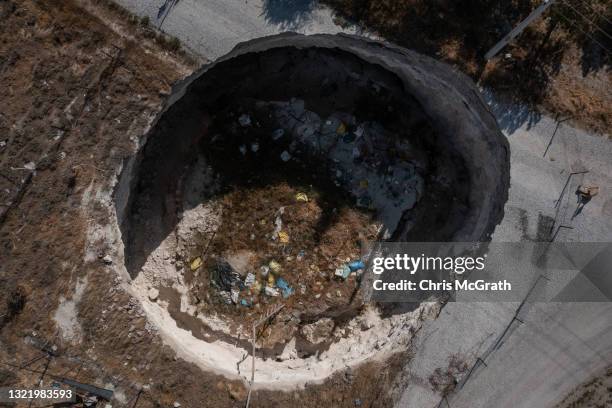 In an aerial view, a large sinkhole is seen cutting a road in the village of Ekmekci on June 03 in Karapinar, Turkey. In Turkey’s Konya province, the...