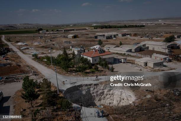 In an aerial view, a large sinkhole is seen cutting a road in the village of Ekmekci on June 03 in Karapinar, Turkey. In Turkey’s Konya province, the...