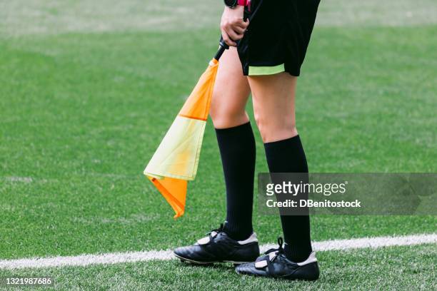 soccer assistant linesman referee woman with the flag on the field of play, moving. - arbitre officiel sportif photos et images de collection