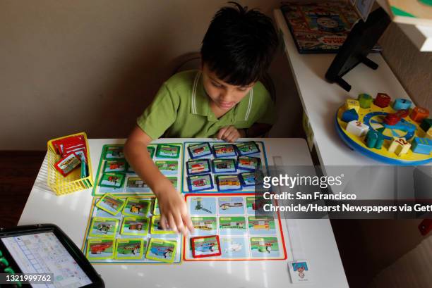 Year-old Nathan Valerio works with the "Teach" system which is specifically designed for autistic children, at his San Bruno, Ca. Home, on Tuesday...