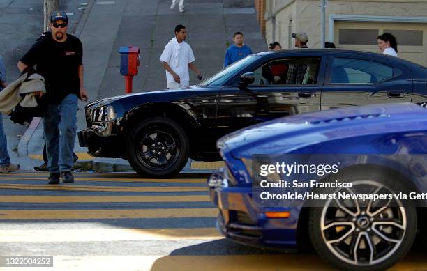 The Ford Mustang and Dodge Charger wait for another take, as the chase scene is filmed along Taylor Street in San Francisco, Ca. On Thursday March 8,...