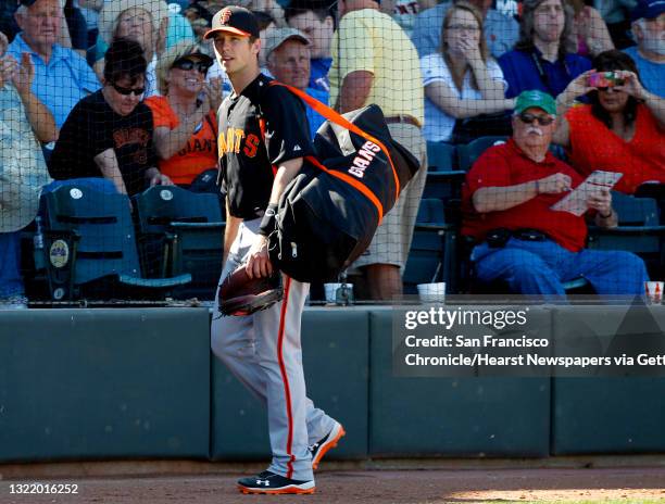 Giants' Buster Posey, finished for the day walks to the clubhouse, at Surprise Stadium on Monday Mar. 11 in Surprise, Az., as the San Francisco...