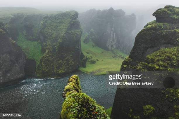 fjadrargljufur canyon in cloudy foggy weather. green moss field. iceland - volcanic landscape stock pictures, royalty-free photos & images