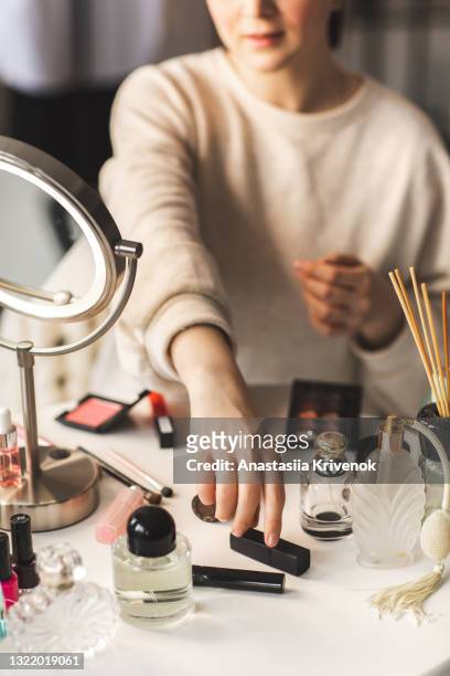 a woman's hand is reaching out to pick up a lipstick from a table full of beauty products - vintage hand mirror stock pictures, royalty-free photos & images