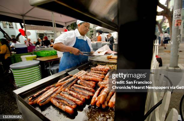 Lucero Munoz, owner of Lucero's Hot Dogs, grills bacon-wrapped dogs at the San Francisco Street Food Festival in the Mission District on Saturday.