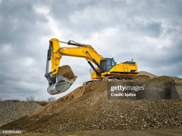 bagger blauer himmel schwere maschine baustelle - excavation stock-fotos und bilder