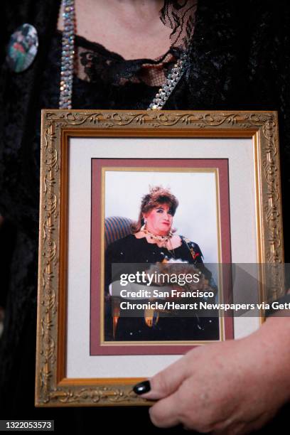 Rose Empress from Portland, Suzanne Hale, carries a formal state portrait of Jose Sarria from her personal collection as she walks through Grace...