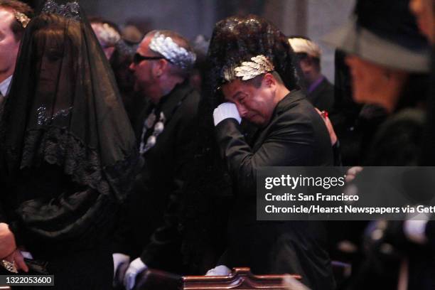 One mourner is comforted by another as they attend the funeral for Jose Julio Sarria at Grace Cathedral on Friday, September 6, 2013 in San...