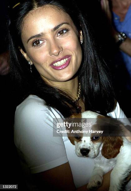 Actress Salma Hayek poses with a puppy during the Harrods Department store "Summer Sale" July 4, 2001 in London.
