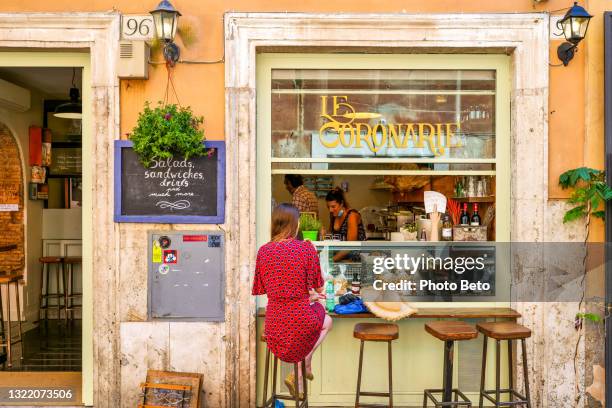 een toerist geniet van het italiaanse leven en eten in een trendy restaurant in het historische hart van rome - italiaanse etniciteit stockfoto's en -beelden