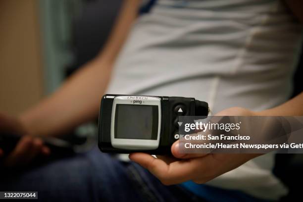 Ella Marks holds her insulin pump while sitting with her brother Jonathan Marks while he receives an infusion at the University of California, San...