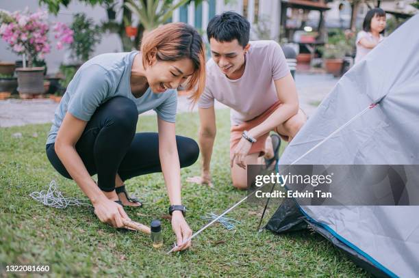 coppia asiatica cinese che alleva tenda accampandosi nel cortile delle attività del fine settimana di soggiorno della casa - picchetto da tenda foto e immagini stock