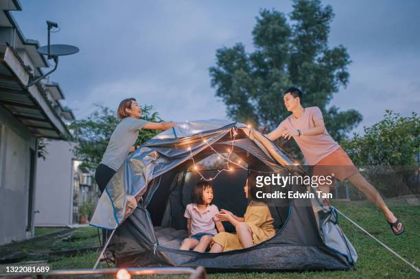 asian chinese family putting on string light decorating camping at backyard of their house staycation weekend activities - atividades de fins de semana imagens e fotografias de stock