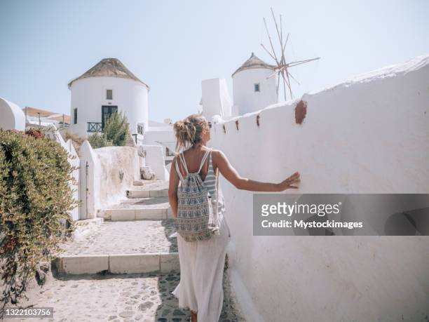 woman contemplates the streets of santorini, greece - mill house stock pictures, royalty-free photos & images