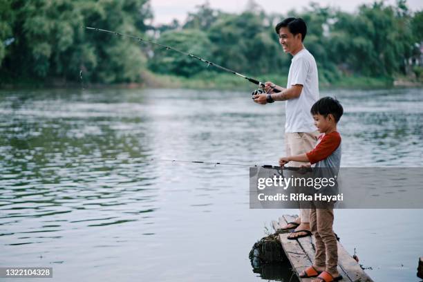 father and son fishing together at the lake - kids fun indonesia stock pictures, royalty-free photos & images
