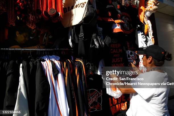 Violeta Cortegana and her sister Lucy Cortegana arrange items in a booth across from AT&T Park as they prepare for Game 6 of the World Series on...