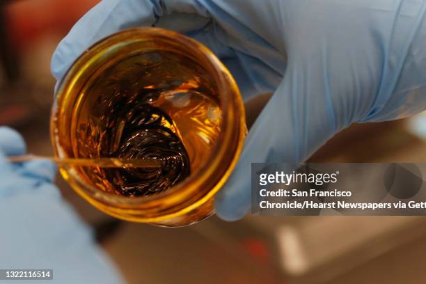 Alexander Zitoli, Steep Hill senior lab technician, collects a sample of a cannabis concentrate as he demonstrates part of the process of working...