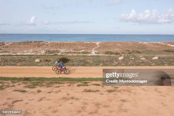 drohnenansicht von bikern an der küste - sardinien stock-fotos und bilder