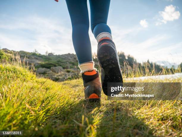 woman hikes up on mountain trail, low angle view - shoes top view stockfoto's en -beelden